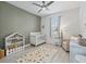 A lovely bedroom offers a ceiling fan, a crib and a beautiful playing rug at 5019 Ne 125Th Loop, Oxford, FL 34484