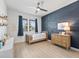 A bedroom featuring a wood accent wall, a ceiling fan, and a window with blue curtains at 5019 Ne 125Th Loop, Oxford, FL 34484