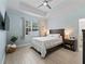 Cozy bedroom with tray ceiling, ceiling fan, and large window creating a peaceful atmosphere at 5019 Ne 125Th Loop, Oxford, FL 34484