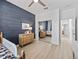 Bedroom showcasing a wood accent wall, a mirror closet, and a view into another room at 5019 Ne 125Th Loop, Oxford, FL 34484