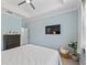 Bedroom with a tray ceiling, ceiling fan, flat screen tv and comfortable furnishings, creating a cozy ambiance at 5019 Ne 125Th Loop, Oxford, FL 34484