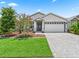 Beautiful single-story home with paver driveway, lush landscaping, and gray-and-white exterior design at 5019 Ne 125Th Loop, Oxford, FL 34484
