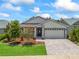 Charming single-story home with a well-manicured lawn, paver driveway and stylish gray and white exterior at 5019 Ne 125Th Loop, Oxford, FL 34484