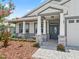 Inviting front porch with stone-clad columns and sitting area, offering a cozy and stylish welcome at 5019 Ne 125Th Loop, Oxford, FL 34484