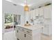 Gourmet kitchen features an island, stainless steel appliances, and sliding glass doors to the outdoor living space at 5019 Ne 125Th Loop, Oxford, FL 34484