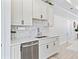 Kitchen area featuring stainless steel dishwasher, faucet, and white cabinets at 5019 Ne 125Th Loop, Oxford, FL 34484