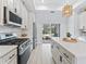 Gourmet kitchen features an island, stainless steel appliances, and sliding glass doors to the outdoor living space at 5019 Ne 125Th Loop, Oxford, FL 34484