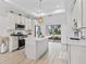 Gourmet kitchen features an island, stainless steel appliances, and sliding glass doors to the outdoor living space at 5019 Ne 125Th Loop, Oxford, FL 34484