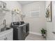 A modern laundry room with stainless steel appliances, window and sink at 5019 Ne 125Th Loop, Oxford, FL 34484