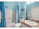 Well-lit bathroom with a shower-tub combo, a white sink, and a decorative shower curtain at 5068 Ne 121St Ave, Oxford, FL 34484
