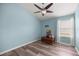 Bright bedroom with wood-look floors, a ceiling fan, and a cozy wooden chest by the window at 5068 Ne 121St Ave, Oxford, FL 34484