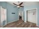 Bright bedroom featuring wood-look floors, a ceiling fan, and a view into the closet and hallway at 5068 Ne 121St Ave, Oxford, FL 34484