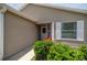Close-up of a charming front porch with a cozy red chair and well-manicured bushes at 5068 Ne 121St Ave, Oxford, FL 34484