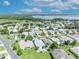 An aerial view of a community with single Gathering homes, manicured lawns, mature trees, and a beautiful lake in the background at 5964 Brittania Blvd, Tavares, FL 32778