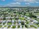 Panoramic aerial view of a well-maintained neighborhood with lush green lawns and mature trees leading to a lake at 5964 Brittania Blvd, Tavares, FL 32778