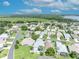 An aerial view of a community with single Gathering homes, manicured lawns, mature trees, and a beautiful lake in the background at 5964 Brittania Blvd, Tavares, FL 32778