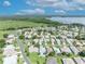 Panoramic aerial view of a well-maintained neighborhood with lush green lawns and mature trees leading to a lake at 5964 Brittania Blvd, Tavares, FL 32778