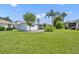 Spacious backyard boasts lush green grass, mature trees, and a screened lanai, perfect for outdoor living at 5964 Brittania Blvd, Tavares, FL 32778