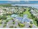 Aerial view showcasing the community center with tennis courts, a covered pool, meticulous landscaping, and lush green spaces at 5964 Brittania Blvd, Tavares, FL 32778