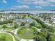 Aerial view of a community center with ponds, fountain, tennis courts, clubhouse, and manicured landscaping at 5964 Brittania Blvd, Tavares, FL 32778