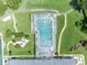 Top-down aerial view of a screened community pool with walking trails, seating, and vibrant green spaces surrounding it at 5964 Brittania Blvd, Tavares, FL 32778