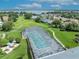 Aerial view of a screened community pool surrounded by walking trails, lush landscaping, and vibrant green spaces at 5964 Brittania Blvd, Tavares, FL 32778