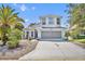 Charming two-story home with a well-manicured lawn, long driveway, and lovely landscaping at 5964 Brittania Blvd, Tavares, FL 32778