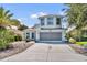 Charming two-story home with a well-manicured lawn, long driveway, and lovely landscaping at 5964 Brittania Blvd, Tavares, FL 32778