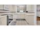 Well-lit kitchen with stainless appliances, neutral countertops and breakfast bar access at 5964 Brittania Blvd, Tavares, FL 32778