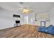 Open living room with wood-look flooring, mini kitchenette, and ceiling fan at 5964 Brittania Blvd, Tavares, FL 32778