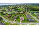 Expansive aerial view of a community featuring lush landscaping, homes, a pond, and a golf course in the distance at 6008 Apex Way, Lady Lake, FL 32159