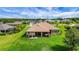 Expansive backyard with lush green lawn, covered patio, and mature trees, perfect for outdoor entertaining and relaxation at 6008 Apex Way, Lady Lake, FL 32159