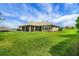 Well-maintained backyard with a vast lawn, mature landscaping, and inviting screened-in porch at 6008 Apex Way, Lady Lake, FL 32159