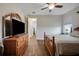 Comfortable bedroom features wood floors, a ceiling fan, and easy access to the ensuite bathroom at 6008 Apex Way, Lady Lake, FL 32159