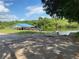 Boat ramp and dock with picnic tables in the background, surrounded by lush greenery and blue water at 6008 Apex Way, Lady Lake, FL 32159