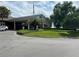 Stately clubhouse featuring meticulously maintained grounds with mature trees and lush greenery at 6008 Apex Way, Lady Lake, FL 32159