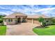 Home featuring an attached garage, paver driveway, manicured landscaping, and inviting curb appeal at 6008 Apex Way, Lady Lake, FL 32159