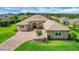 Beautiful single-story home with well-manicured lawn, mature landscaping, and a brick paved drive-way, creating an inviting curb appeal at 6008 Apex Way, Lady Lake, FL 32159