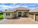 Exterior view of a home featuring a brick driveway, double door entry, and mature landscaping at 6008 Apex Way, Lady Lake, FL 32159