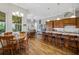 Beautiful kitchen features a breakfast bar, wood cabinets and floors, and an open view to dining and sunroom at 6008 Apex Way, Lady Lake, FL 32159