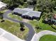 This aerial view showcases the home's well-designed layout, complemented by mature trees and a winding driveway at 604 Ponderosa Dr, St Cloud, FL 34769