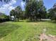 Expansive backyard featuring mature trees, lush greenery, and plenty of space for outdoor activities and relaxation at 604 Ponderosa Dr, St Cloud, FL 34769