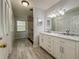 Bright bathroom featuring a dual sink vanity with a tiled shower and storage at 604 Ponderosa Dr, St Cloud, FL 34769