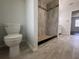 Bright bathroom features wood-look tile flooring, walk-in shower with decorative tile accents, and updated fixtures at 604 Ponderosa Dr, St Cloud, FL 34769