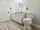Bright bathroom with white cabinets, a toilet, and a neutral-toned wood-look floor at 604 Ponderosa Dr, St Cloud, FL 34769