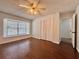 Bedroom with wood floors, large window with white blinds and a closet with shutter doors at 604 Ponderosa Dr, St Cloud, FL 34769