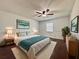 Cozy bedroom with hardwood floors, a ceiling fan, and a comfortable bed at 604 Ponderosa Dr, St Cloud, FL 34769