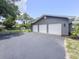 Exterior of a modern home showcasing a three-car garage with white doors and a paved driveway in a well-kept yard at 604 Ponderosa Dr, St Cloud, FL 34769