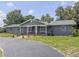 View of the gray-colored single story home featuring a well-manicured lawn and inviting front entrance at 604 Ponderosa Dr, St Cloud, FL 34769