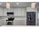 Updated kitchen with white herringbone backsplash, stainless appliances, and modern lighting at 604 Ponderosa Dr, St Cloud, FL 34769